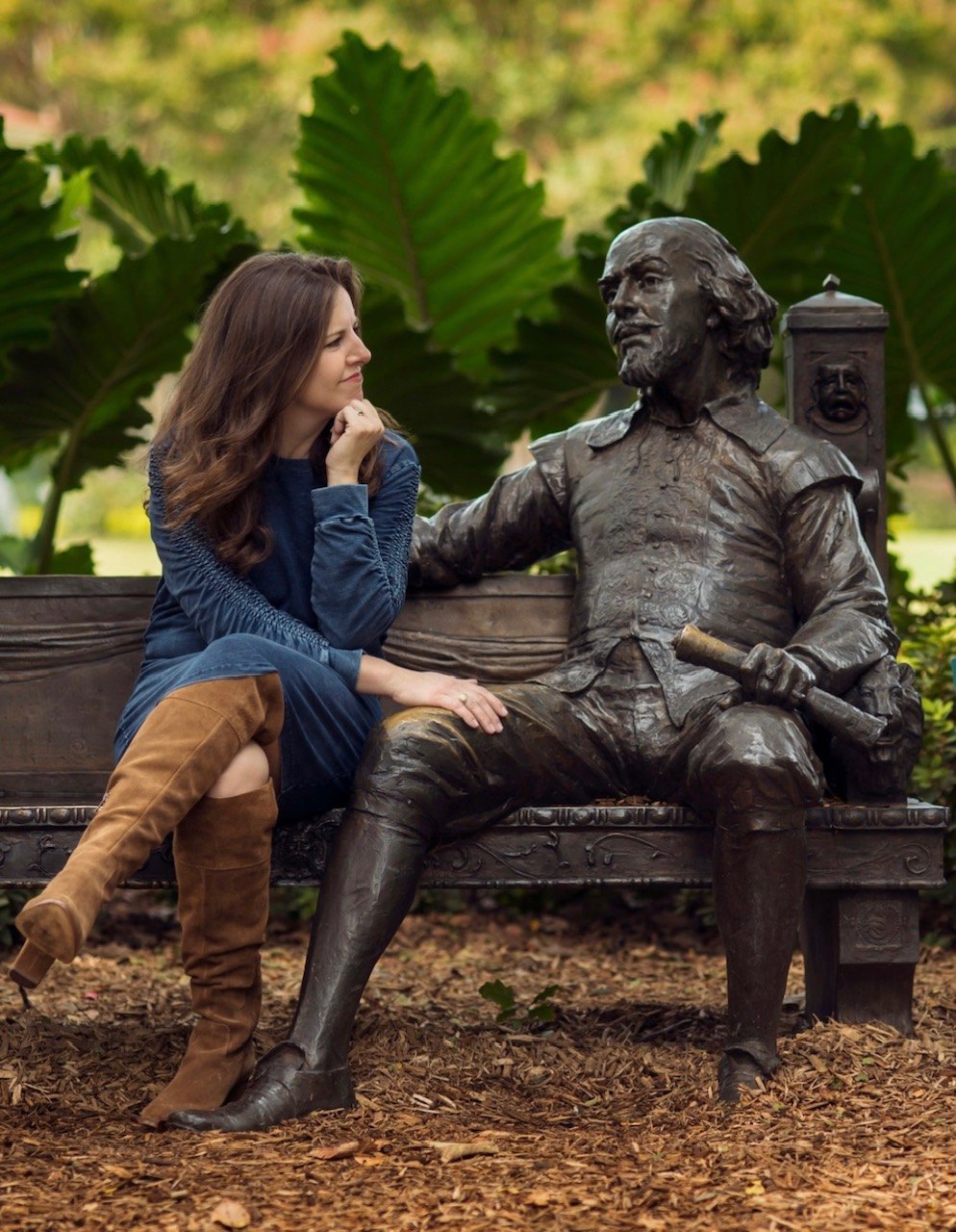 Emily on a park bench beside a bronze statue of Shakespeare, chin in hand, as if mid-conversation